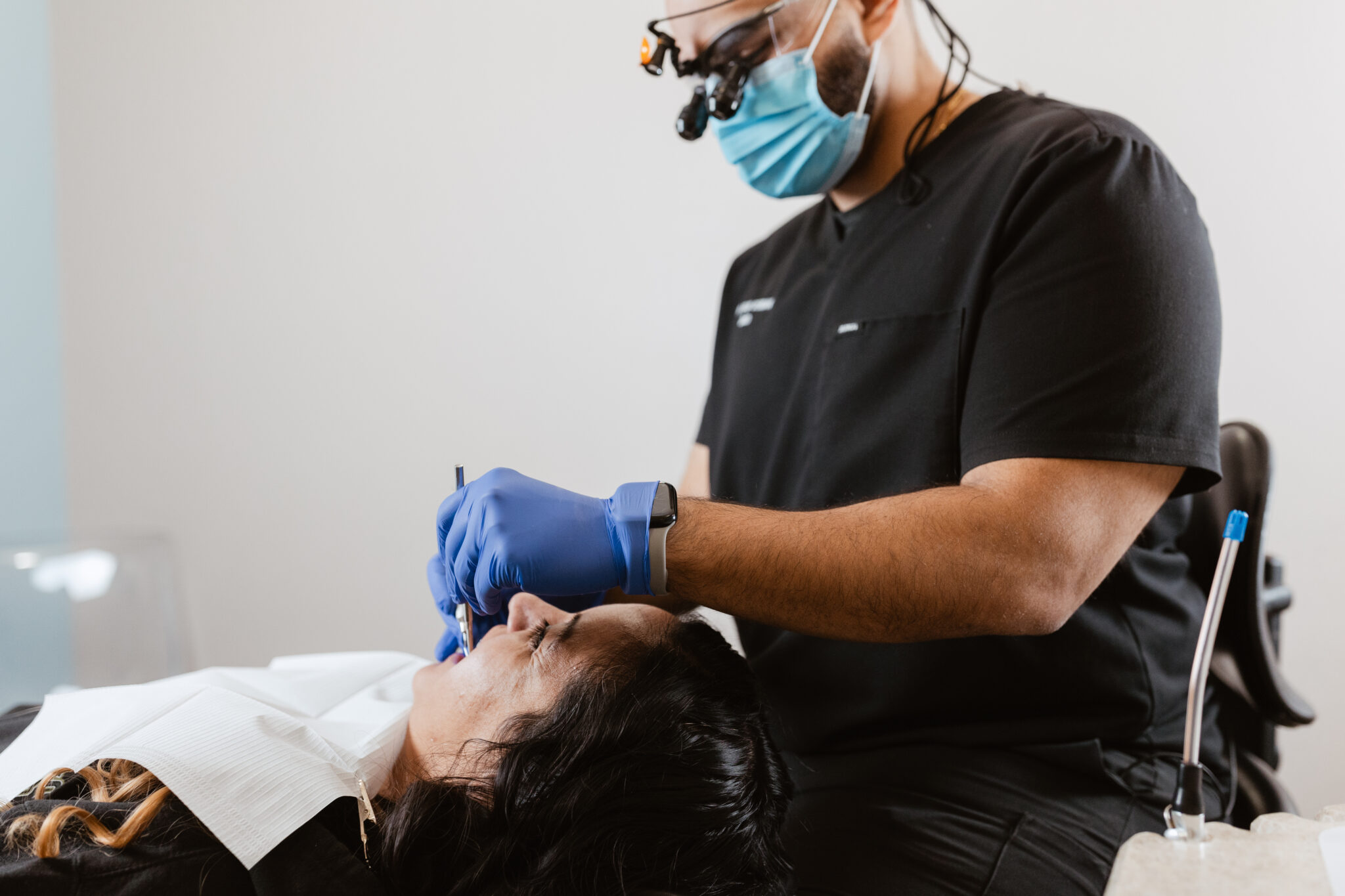Dr. Fadi Demian, DMD, wearing a mask and magnifying loupes, performing a dental procedure on a patient at Centerpoint Dental in Yucaipa, CA